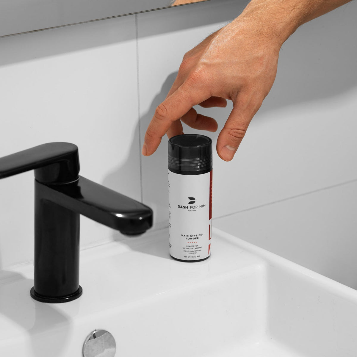 DASH FOR HIM Hair Styling Powder bottle on a bathroom sink, a hand reaching for it