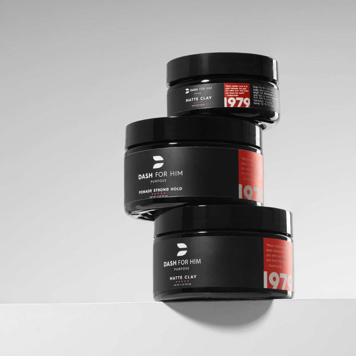 Three stacked DASH FOR HIM jars — Matte Clay and Pomade Strong Hold — on a light studio background.